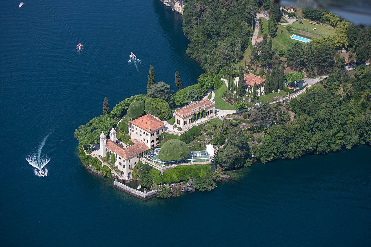 Villa del Balbianello na zalesněném ostrohu nad Comským jezerem, pohled z vody