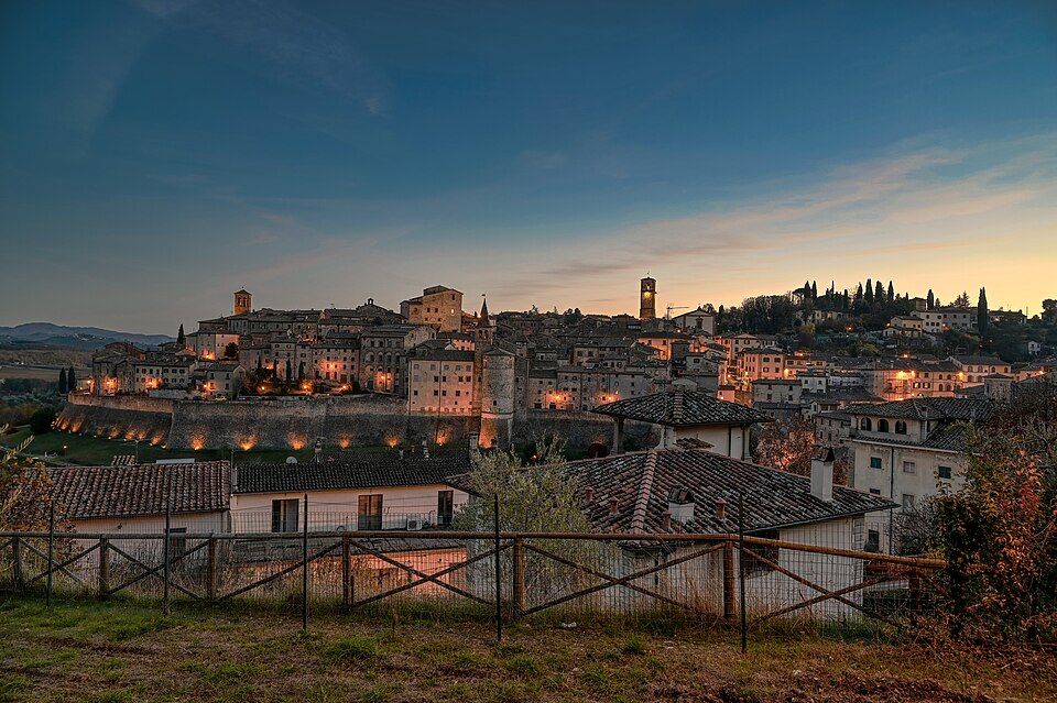 Anghiari za soumraku, město na kopci ve večerním světle