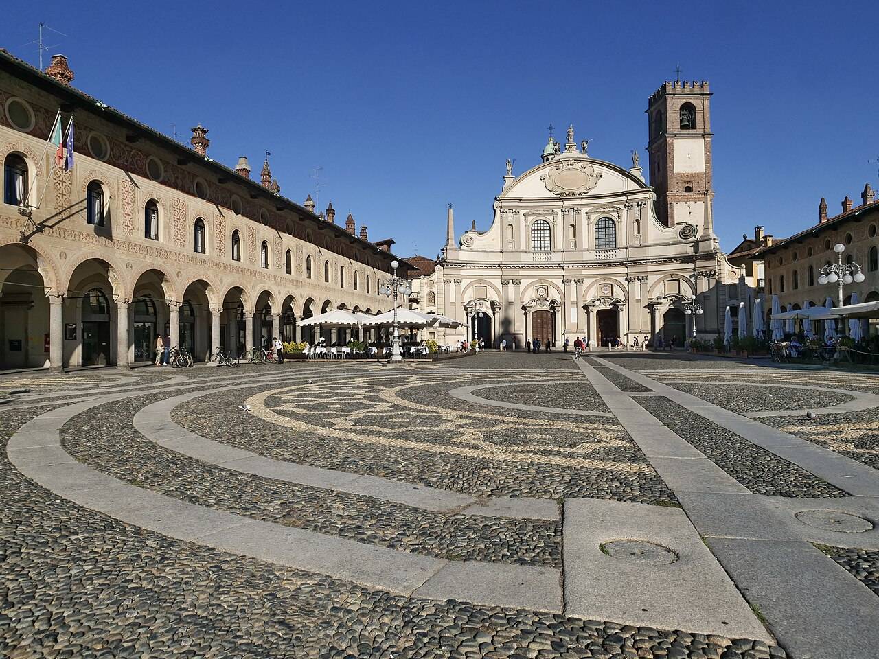 Renesanční Piazza Ducale ve Vigevanu s arkádami, vyklenutou fasádou dómu a věží Bramante