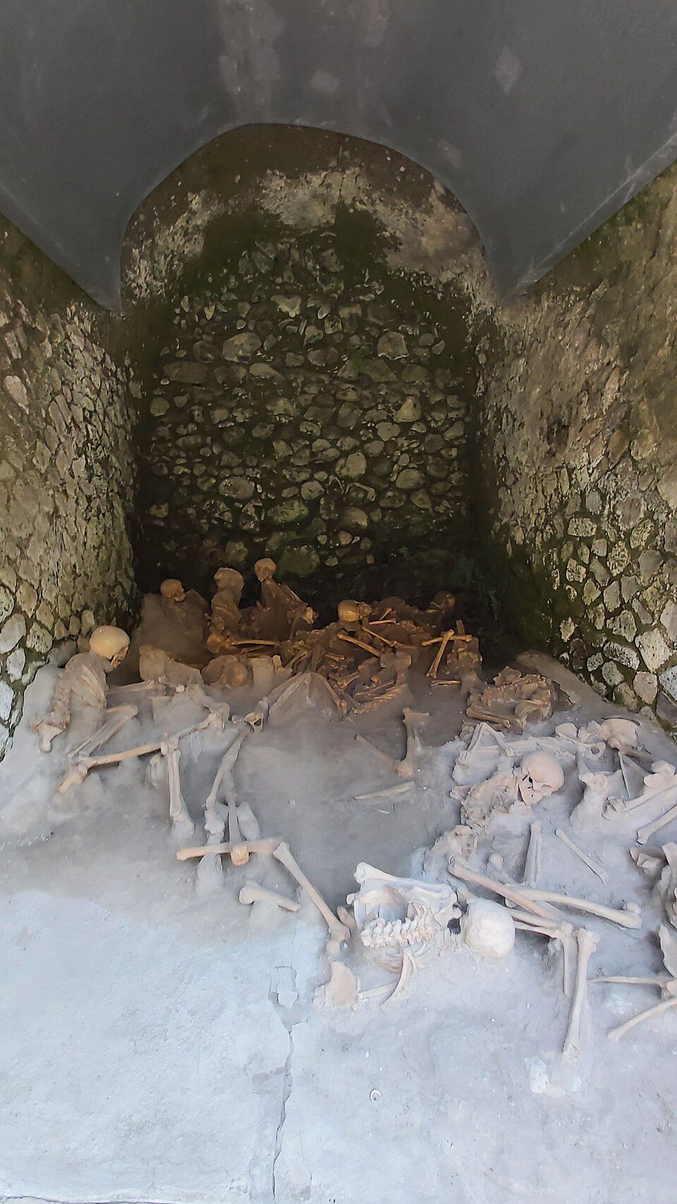 Kostry obětí v dochovaných loděnicích na antické pláži Herculanea