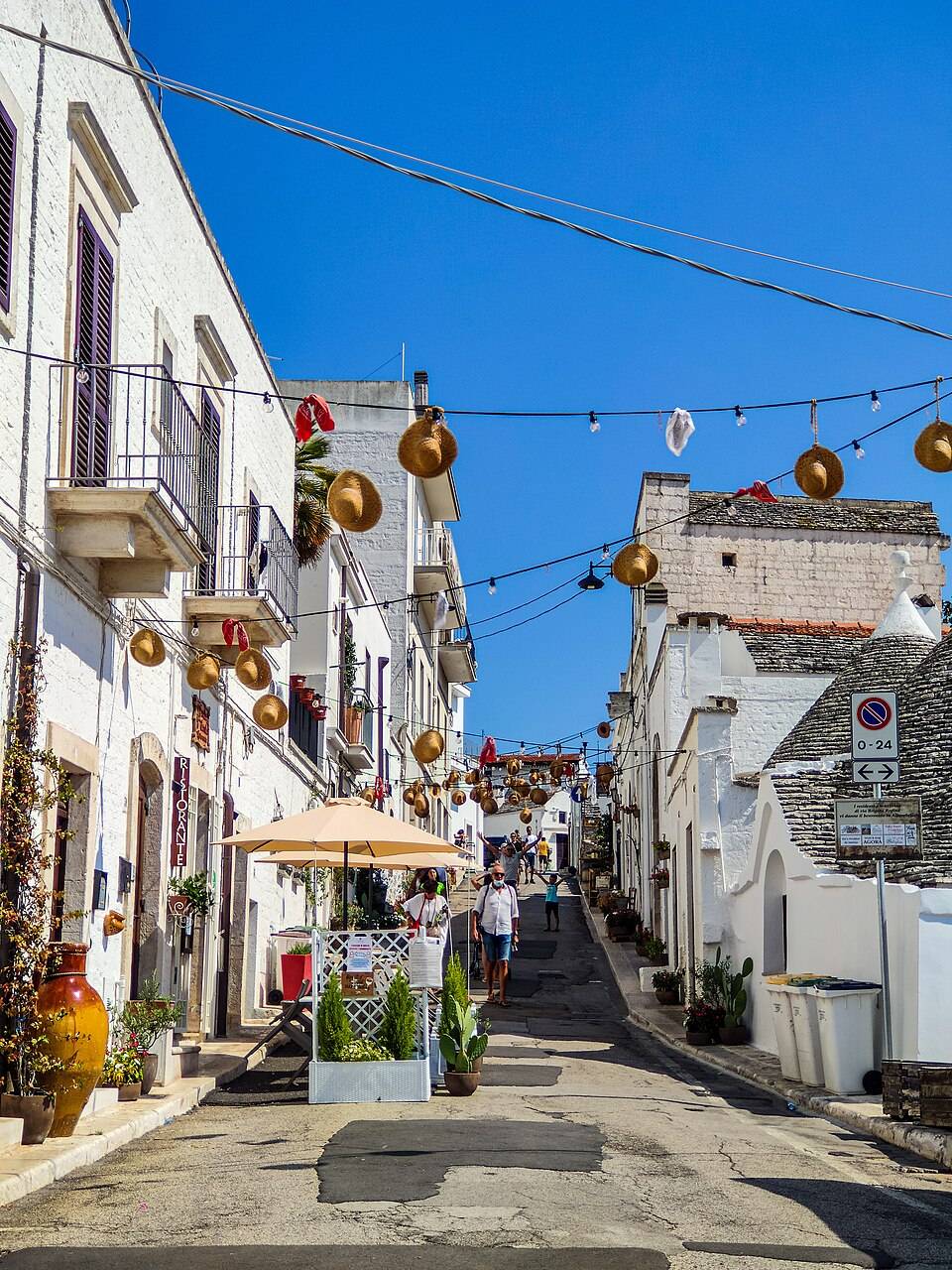 Dlážděná ulička lemovaná bílými trulli