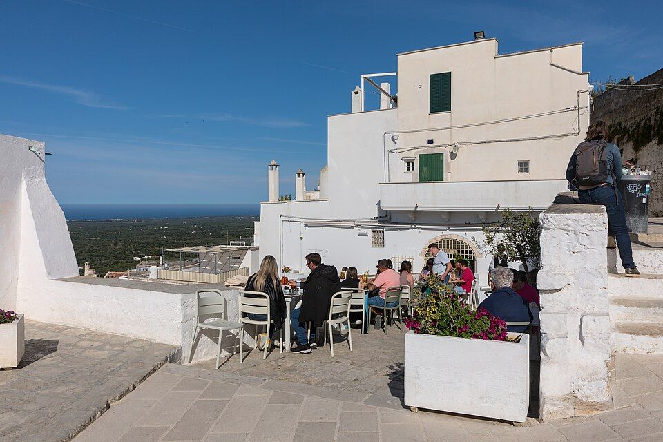 Bistrot Borgo Antico v historickém centru Ostuni — letní terasa ve stínu bílých zdí