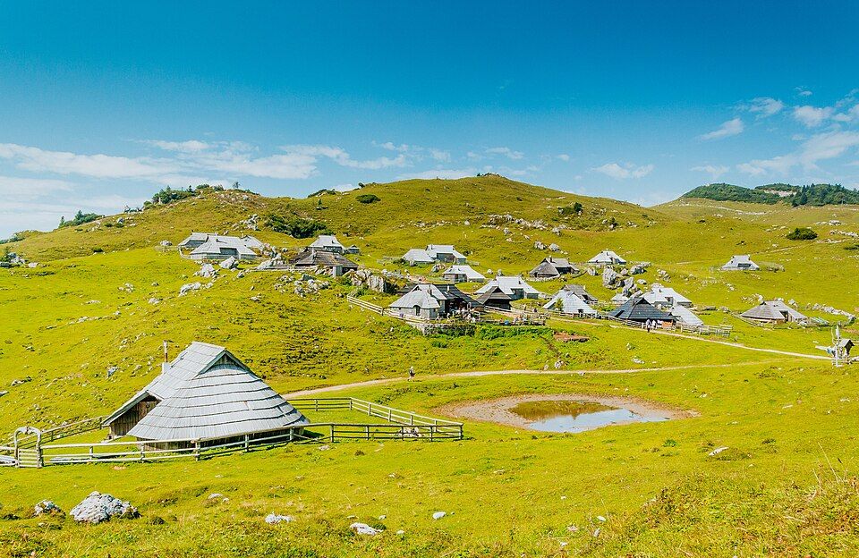 Panoramatický záběr na skupinu bud Velika planiny s Kamnicko-Savinjskými Alpami v pozadí