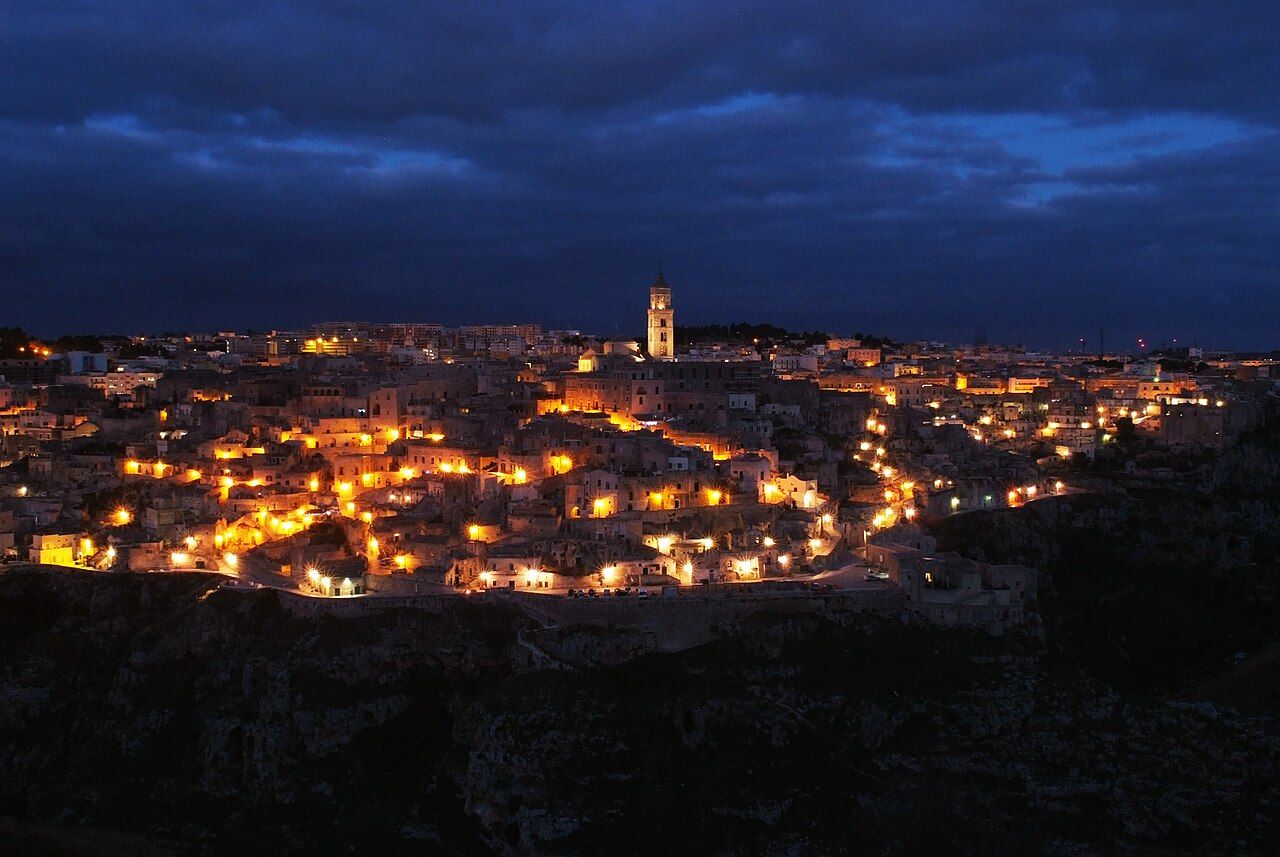 Sassi di Matera za soumraku — jeskynní město rozsvícené tisíci světel ve skalní strži