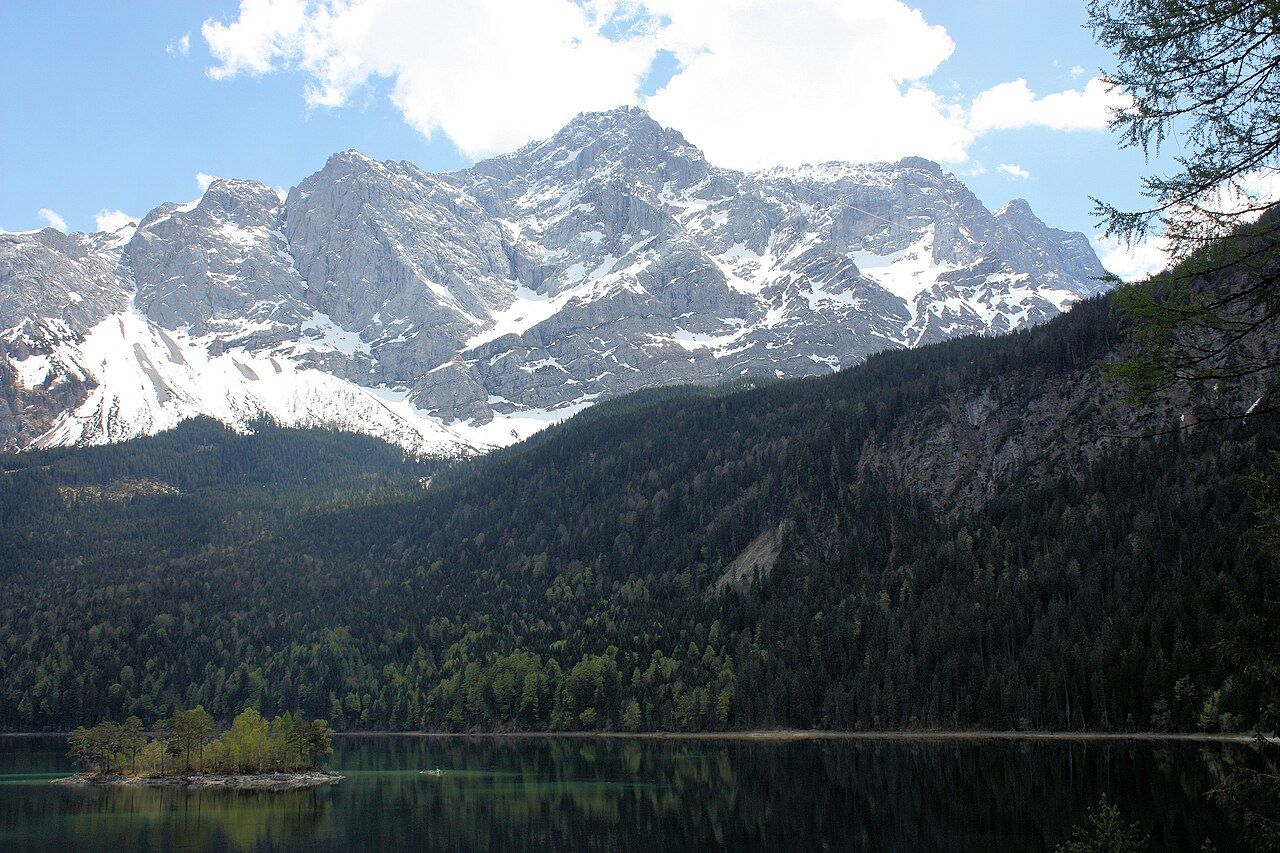 Tyrkysové jezero Eibsee s ostrůvky a masivem Zugspitze v pozadí