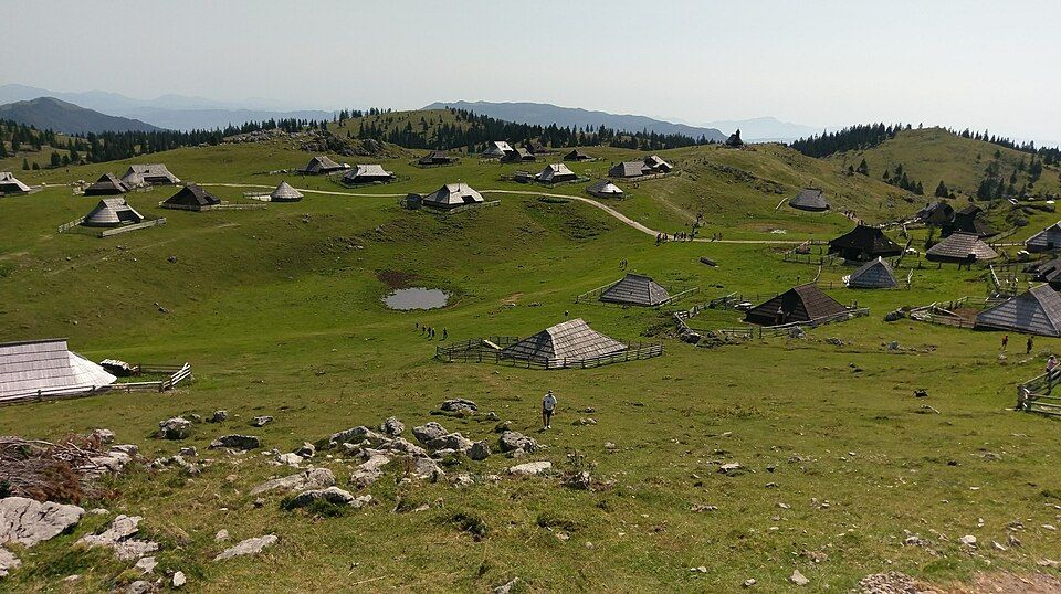 Tradiční oválné pastýřské boudy s šindelovou střechou na Veliki planině