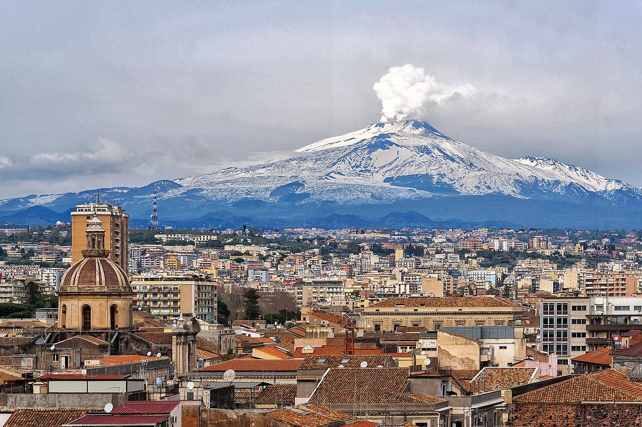 Etna se sněhem na vrcholu nad městem Catania na Sicílii