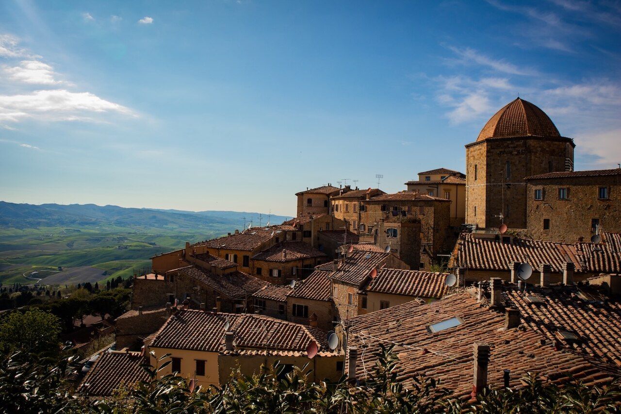 Volterra na vrcholu kopce nad toskánskou krajinou za soumraku