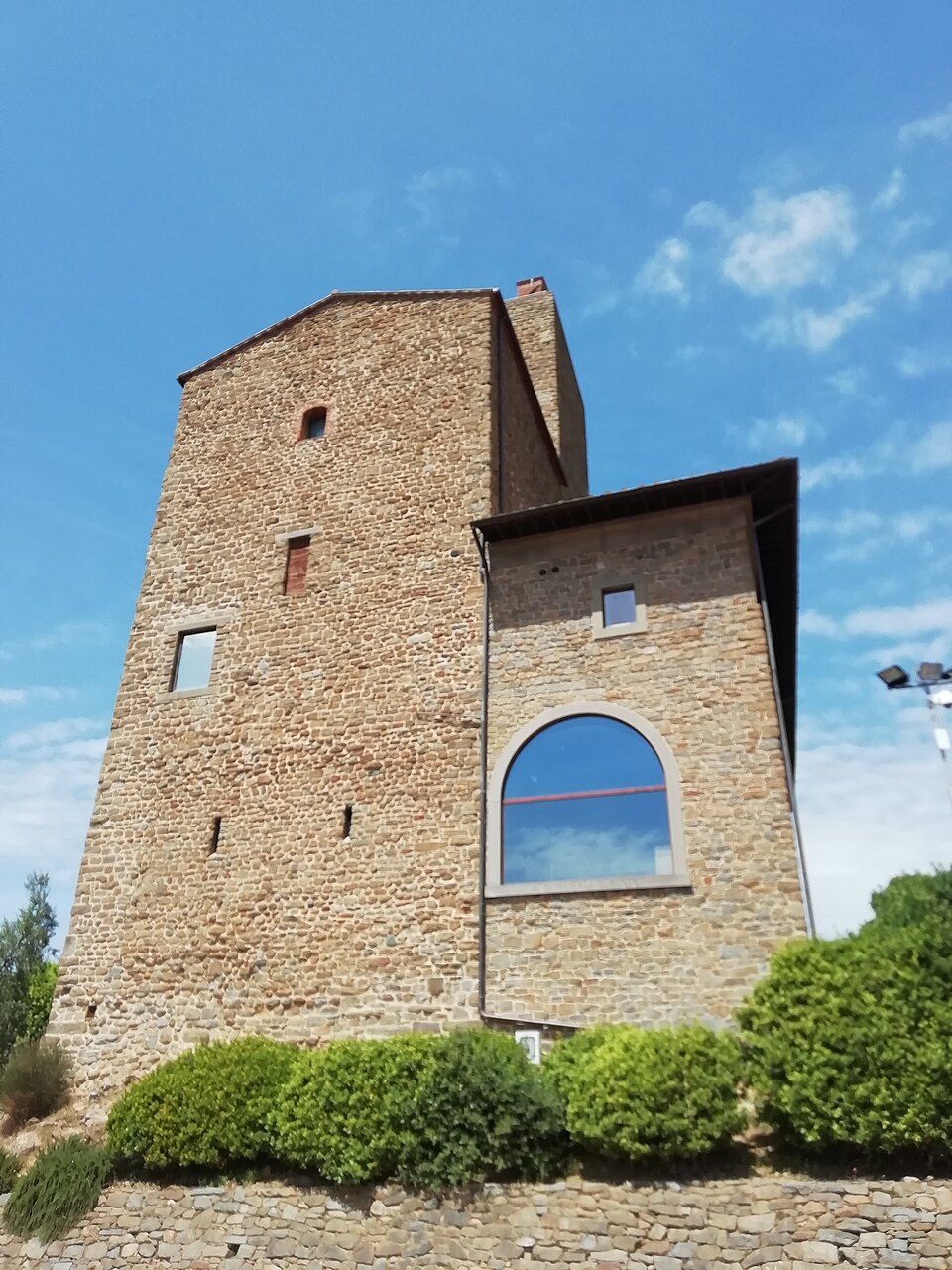 Hrad Guidi ve Vinci se špičatou věží nad střechami městečka
