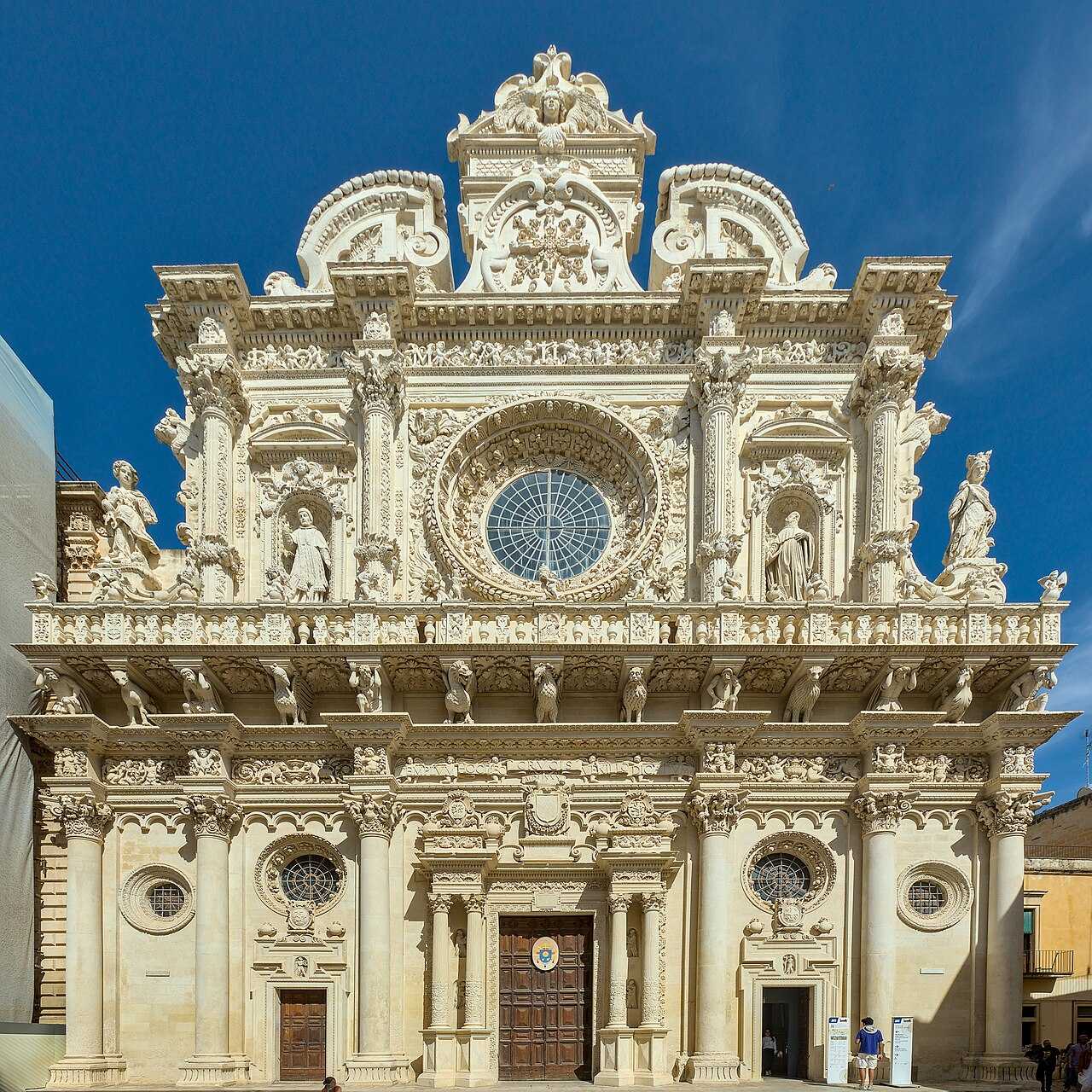 Bohatě tesaná barokní fasáda baziliky Santa Croce v Lecce ze zlatého kamene