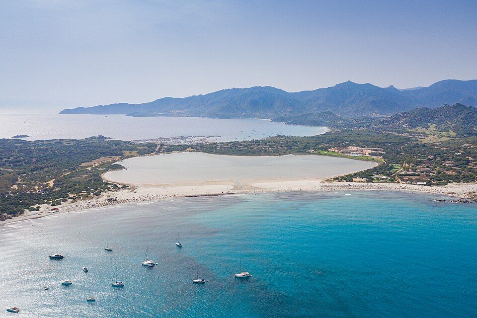 Letecký pohled na slanou lagunu Stagno di Notteri s marinaou Villasimius v pozadí