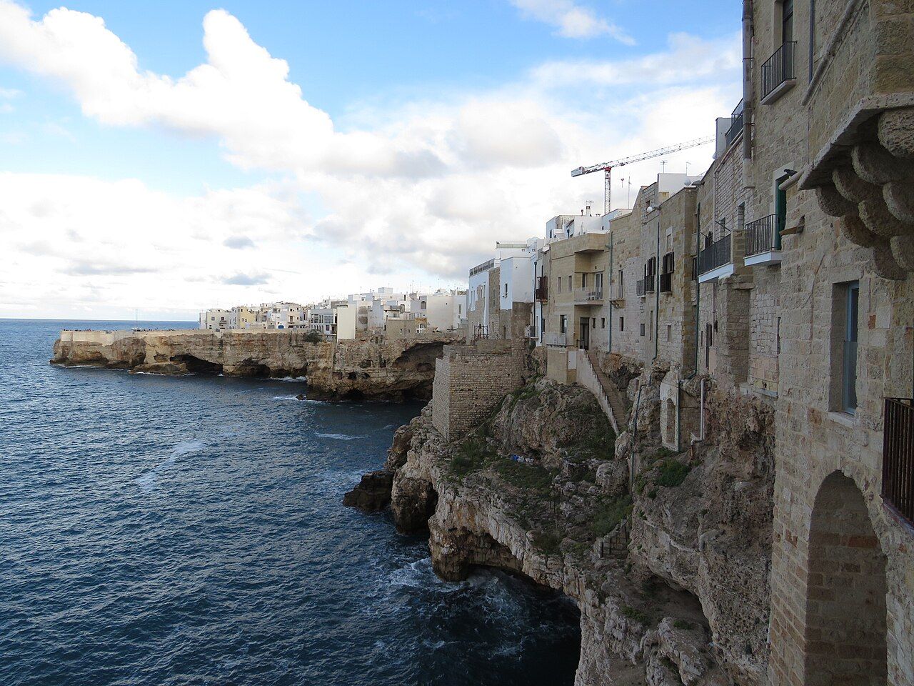 Polignano a Mare — vápencové útesy s jeskyněmi nad Jaderským mořem, pohled z vyhlídky Vico Gualdella