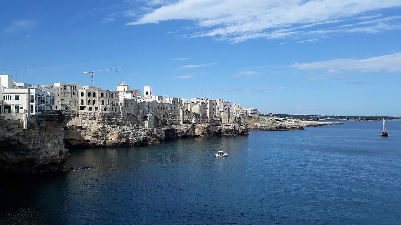 Polignano a Mare — bílé domy na vápencových útesech nad tyrkysovým mořem