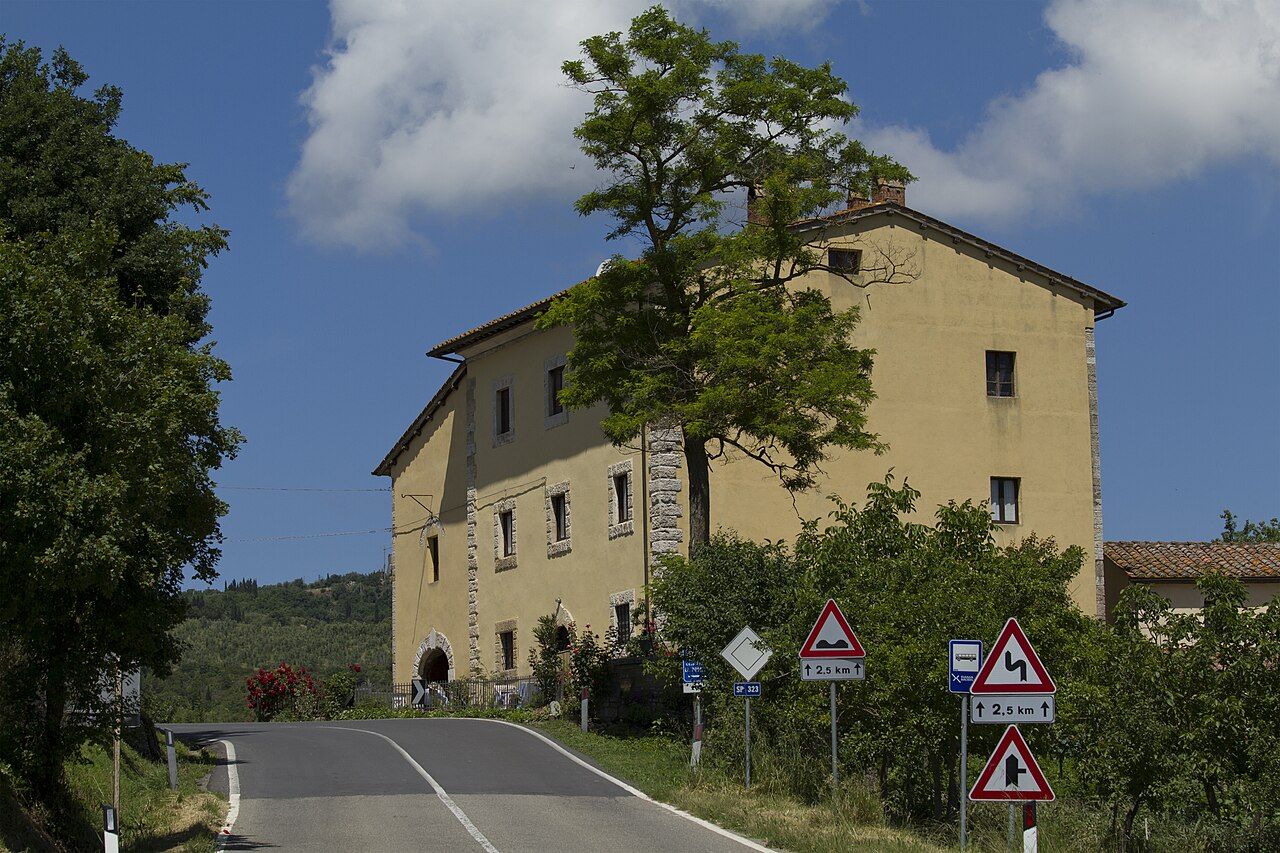Termální bazén uprostřed návsi v Bagno Vignoni obklopený kamennými domy, nad hladinou stoupá pára