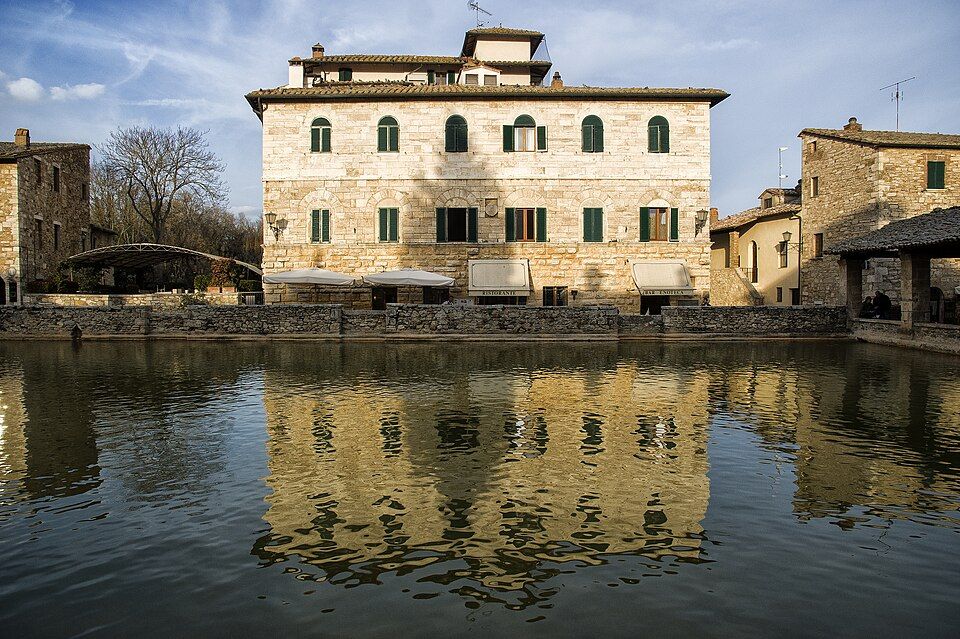 Termální bazén Bagno Vignoni s odrazem domů na hladině