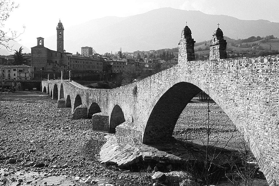 Detail nepravidelných kamenných oblouků Ponte Gobbo nad štěrkovým řečištěm