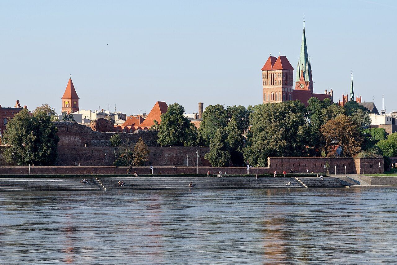 Cihlové hradby Toruně a věže Starého Města nad hladinou Visly