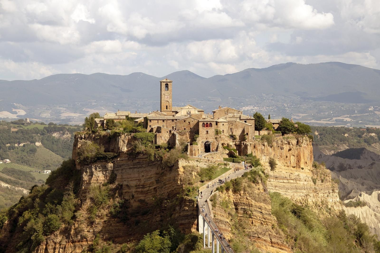 Středověké městečko Civita di Bagnoregio na osamělé tufové skále, spojené s okolím úzkou pěší lávkou
